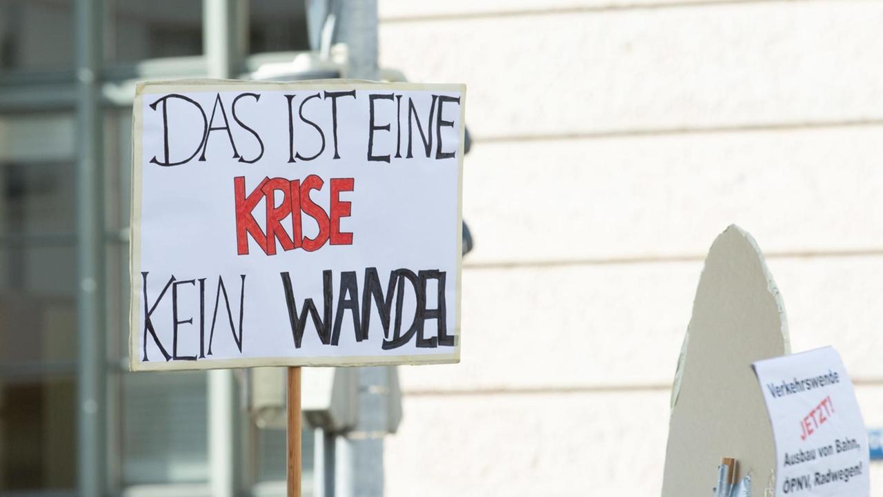 Ein Teilnehmer der "Munich For Future"-Demonstration am 21. Juli 2019 hält ein Plakat mit der Aufschrift "Das ist eine Krise - kein Wandel" hoch .