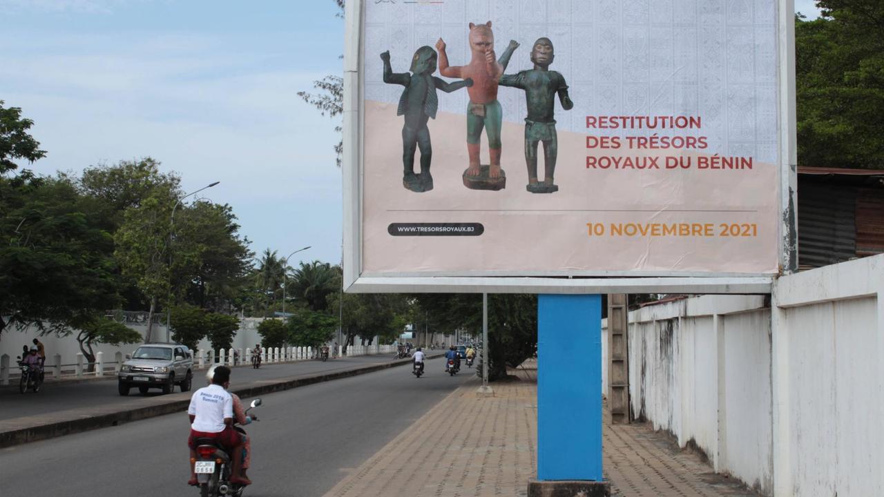 Plakat in Benins Hauptstadt Cotonou kündigt die Ankunft der von Frankreich zurückgegebenen Kunstwerke an, die während der Kolonialzeit im 19. Jahrhundert geraubt worden waren