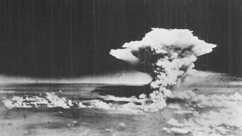 Eine Luftaufnahme (schwarz-weiß) vom 6. August 1945 zeigt einen Atompilz über Hiroshima.