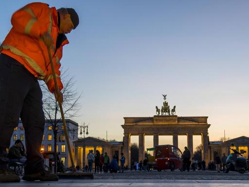 Ein Mann reinigt den Ausgang des U-Bahnhofes Brandenburger Tor in Berlin.