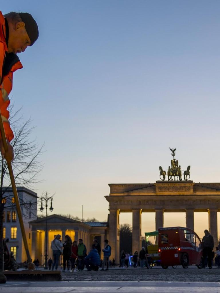 Ein Mann reinigt den Ausgang des U-Bahnhofes Brandenburger Tor in Berlin.