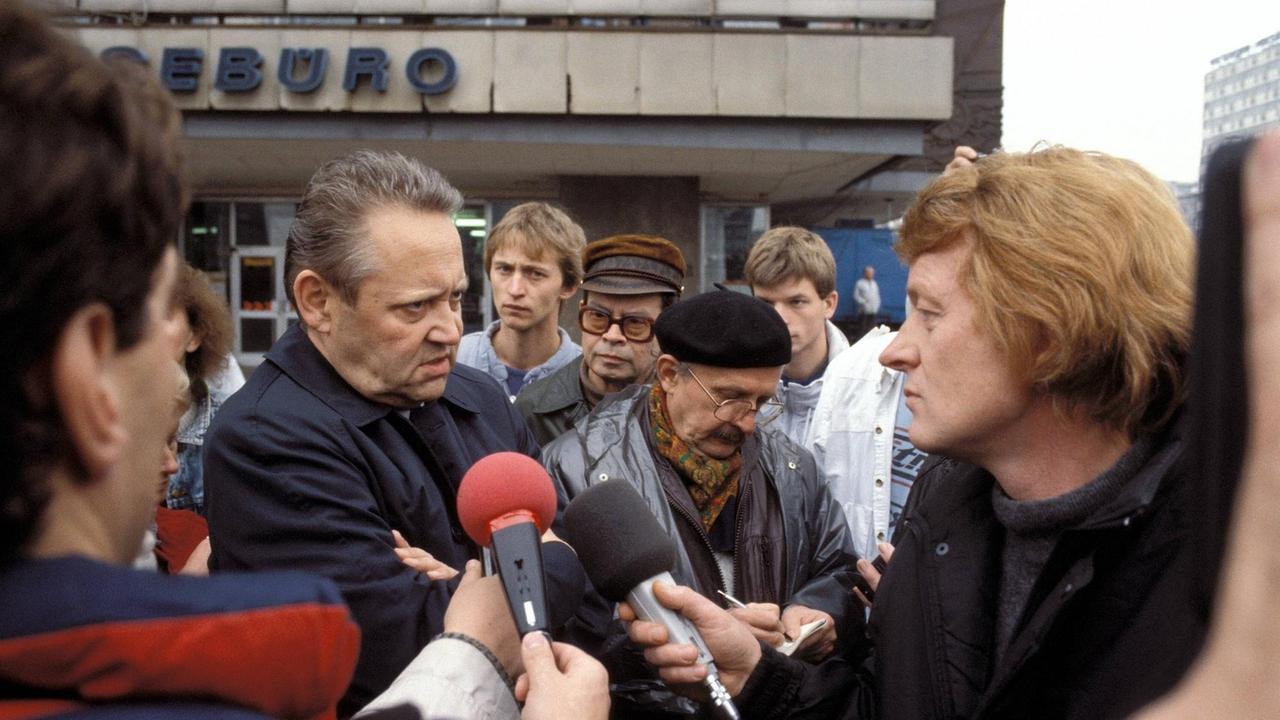 Günter Schabowski, Mitglied des ZK der SED, steht am 04.11.1989 während der Protestkundgebung in Berlin-Mitte zwischen Reportern