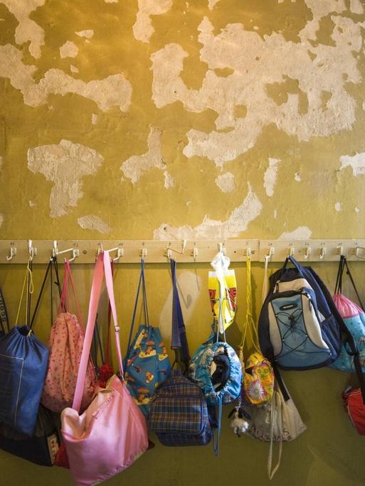 Putzschäden an einer Garderobenwand einer Grundschule
