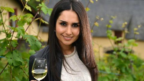 Ninorta Bahno aus Syrien posiert am 28.06.2016 in einem Weinberg in Trier (Rheinland-Pfalz) mit einem Glas Riesling-Wein.