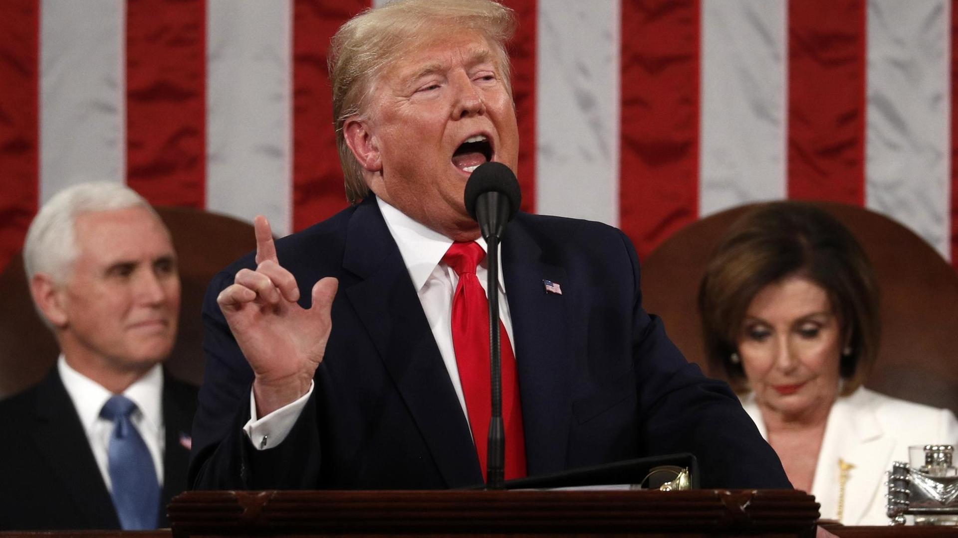 US-Präsident Trump steht an einem Rednerpunkt und spricht mit erhobenem Finger.