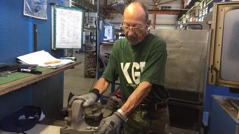 Ein Rentner bei seiner Arbeit an einer Werkbank