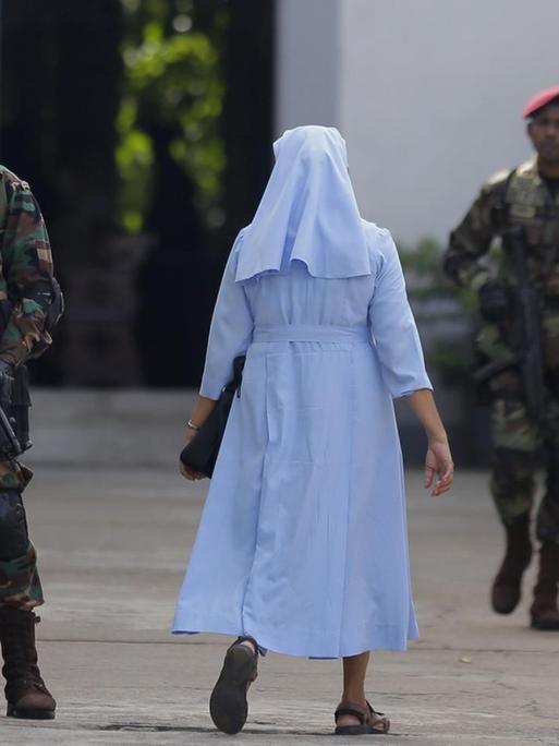 Nach den Anschlägen mit 258 Toten in Sri Lanka ist in der Hauptstadt Colombo erstmals wieder die katholische Sonntagsmesse gefeiert worden. Das Bild zeigt Soldaten, die eine Maschinenpistolen eine Kirche bewachen.