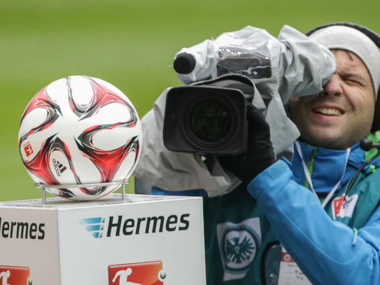 Ein Kameramann filmt den Ball vor einem Bundesligaspiel.