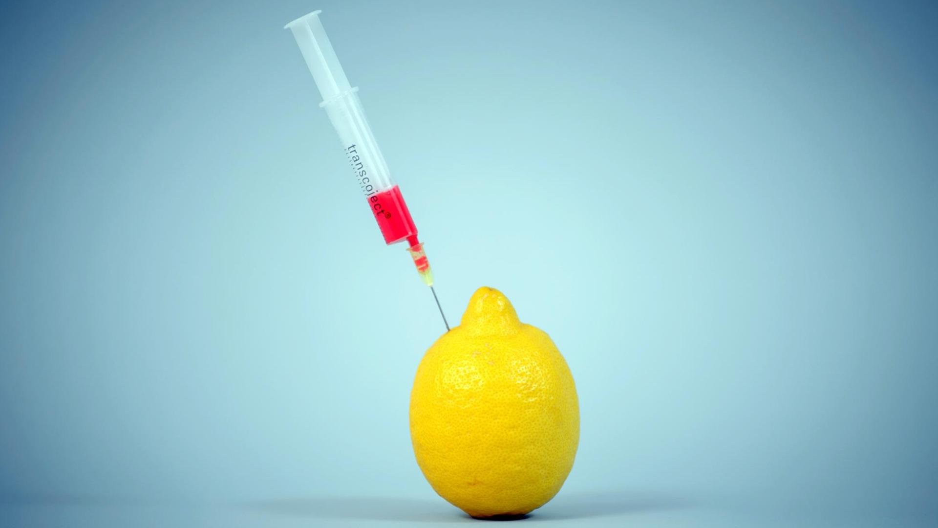 Eine Spritze samt Injektionsnadel mit roter Flüssigkeit steckt in einer Zitrone, aufgenommen am 02.02.2015 in Dresden (Sachsen). Foto: Thomas Eisenhuth | Verwendung weltweit