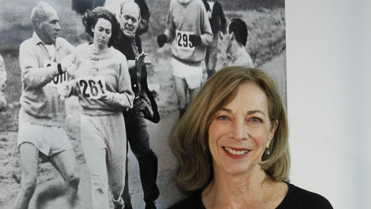 Frauenmarathon-Pionierin Kathrine Switzer lehnt vor einem alten Foto, das ihren ersten Marathon-Lauf 1967 zeigt.