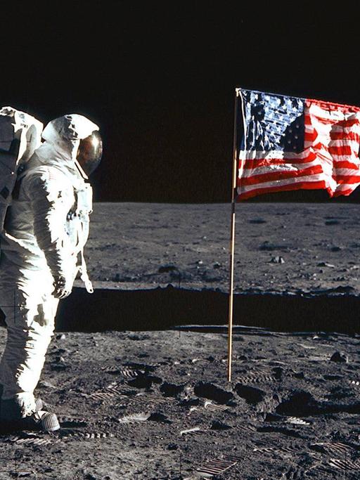 Astronaut Buzz Edwin Eugene Aldrin (USA) neben der amerikanischen Fahne auf dem Mond während der Mission Apollo 11.