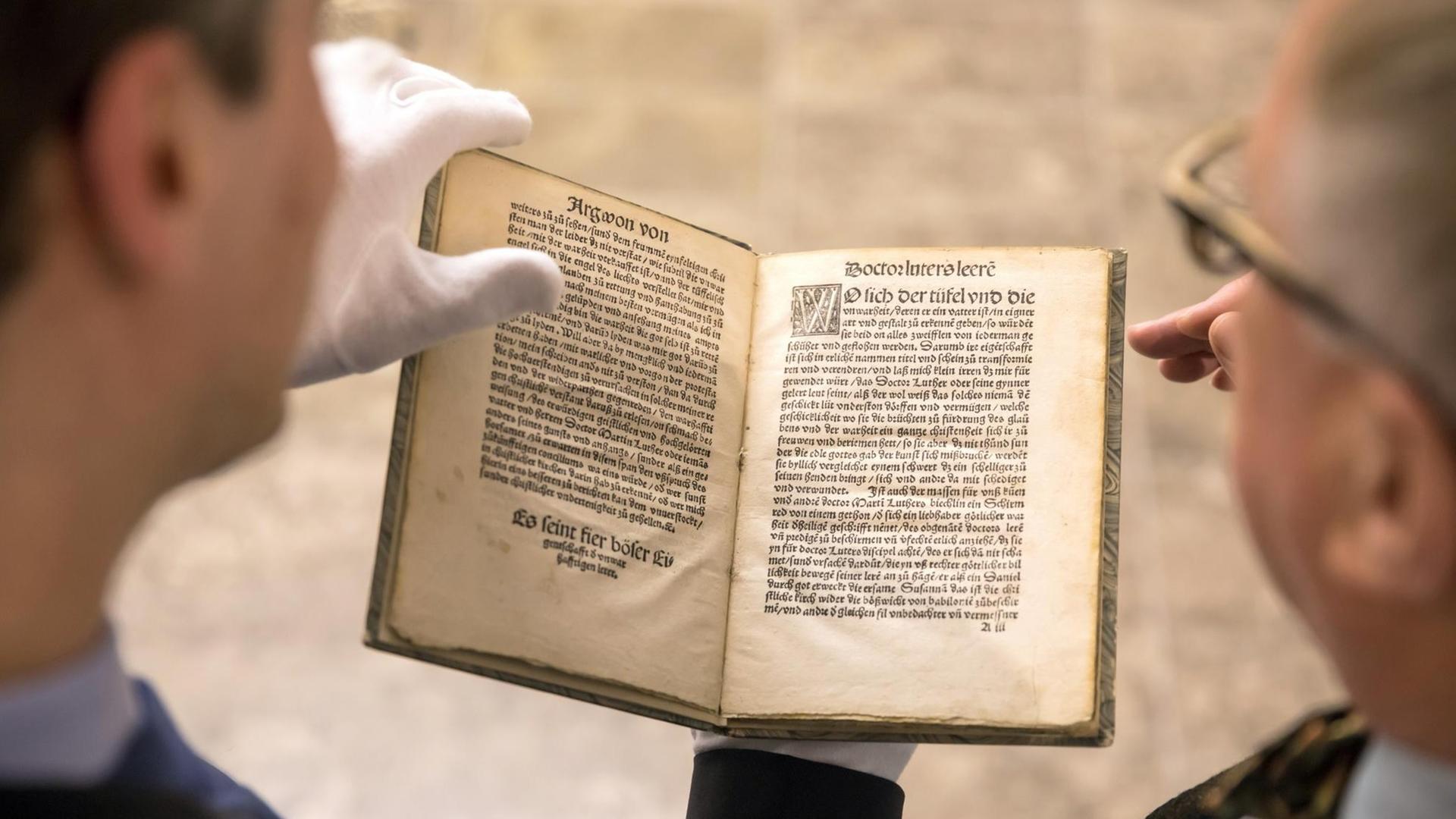 Die Idee der Streitschrift ist alt: Zwei Männer betrachen die anti-lutherische Streitschrift von Thomas Murner von 1520.