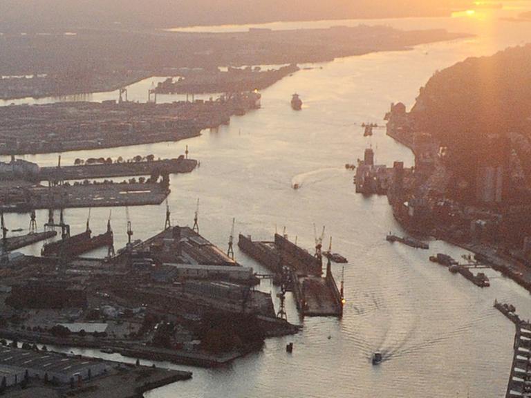 Teile des Hamburger Hafens und die Elbe im Licht der untergehenden Sonne.