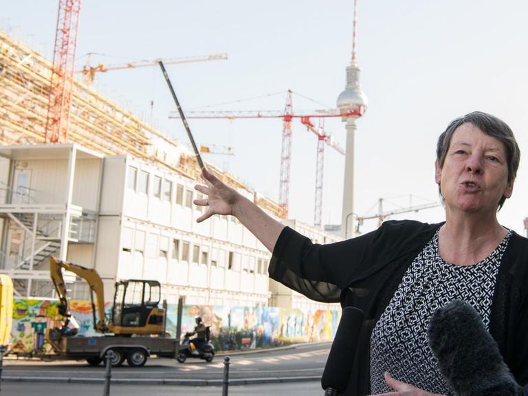 Bundesbauministerin Barbara Hendricks (SPD) deutet bei einem Interview auf die Baustelle des Berliner Schlosses in Berlin.