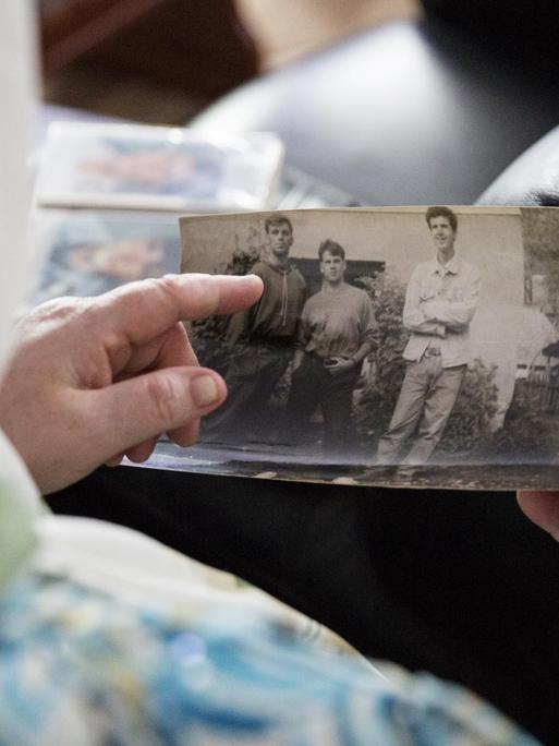 Zineta Ibisevic hält ein Foto ihrer Kinder in den Händen. Die Familie Ibisevic hat ihre beiden Söhne 1995 beim Völkermord an Srebrenica verloren.
