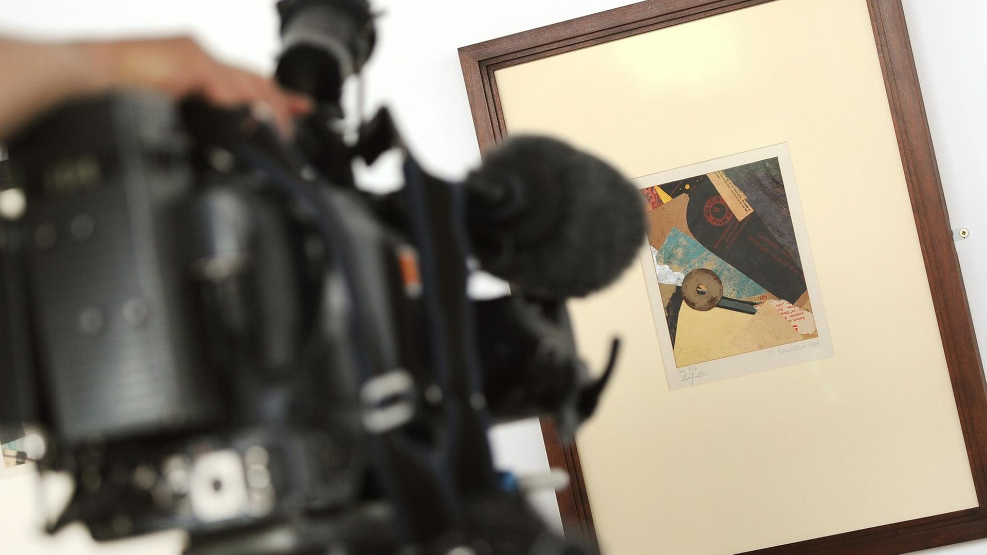 Ein Kameramann filmt das Kunstwerk "Deshalb" (Merzbild 356, 1921) von Kurt Schwitters am 07.07.2014 auf einer Pressekonferenz der Stiftung Preußischer Kulturbesitz in Berlin.