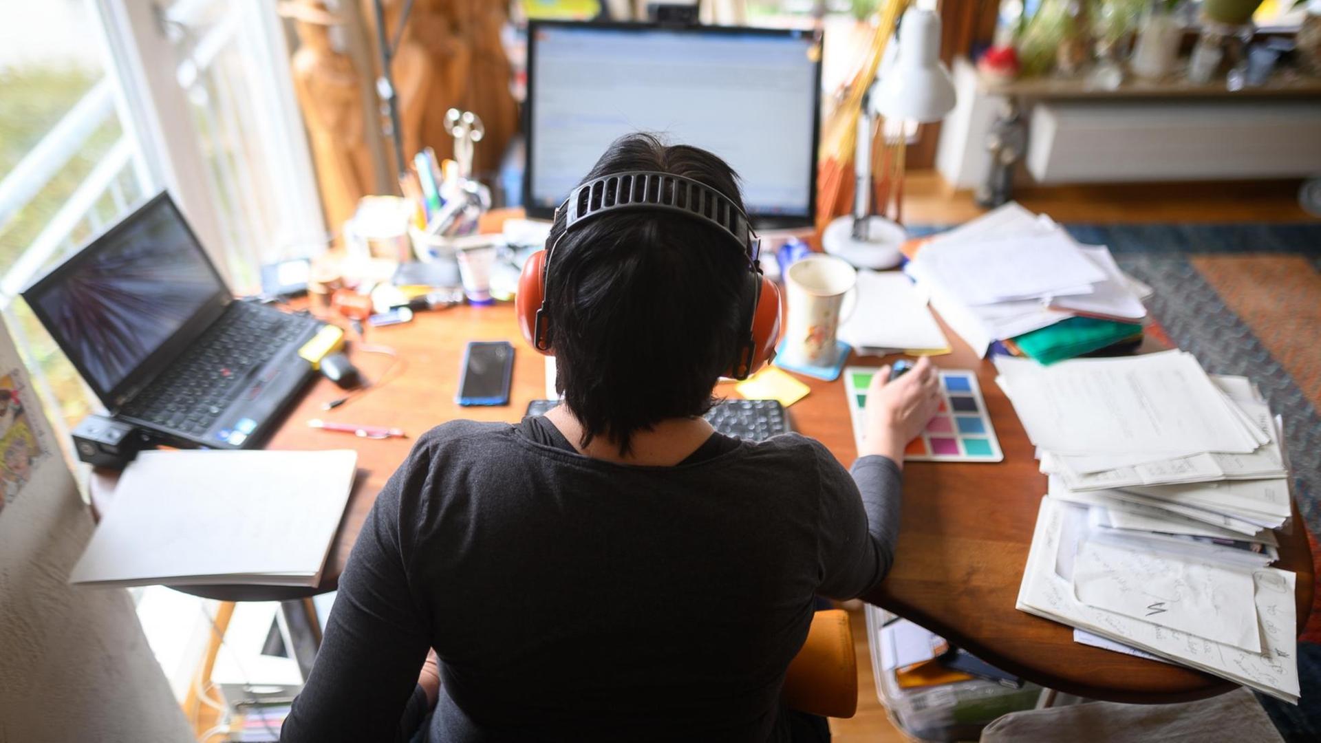 Eine Frau arbeitet im Homeoffice an ihrem Schreibtisch