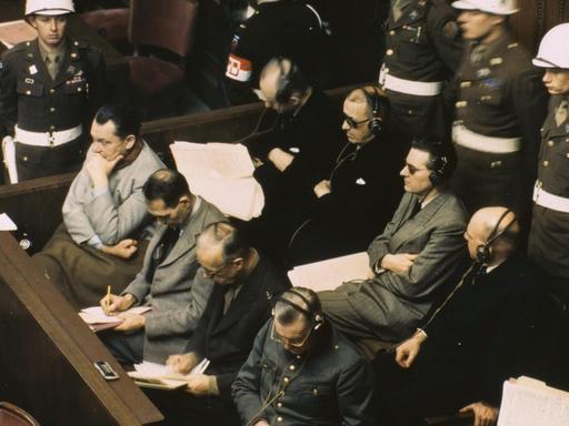 Anklagebank im Nürnbergers Prozess am 20.11.1945: 1. Reihe v.l., Göring, Hess, Ribbentrop, Keitel; 2. Reihe, v.l., Dönitz, Raeder, von Schirach, Sauckel und Jodl.