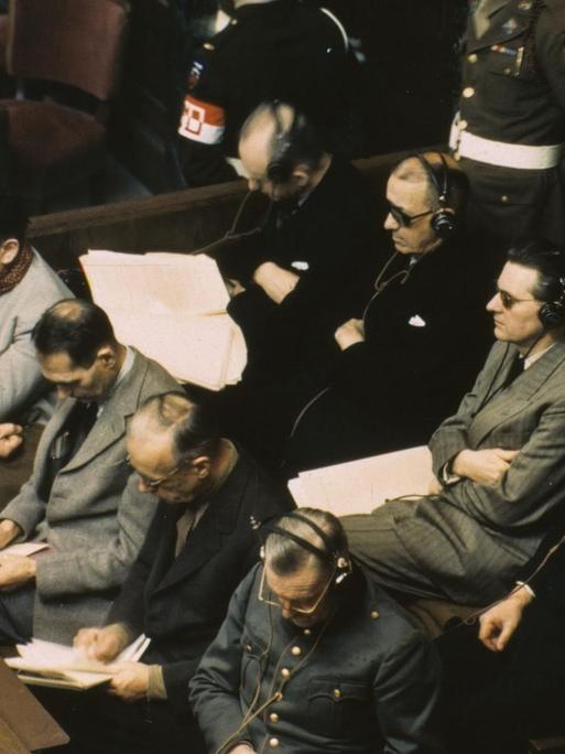 Anklagebank im Nürnbergers Prozess am 20.11.1945: 1. Reihe v.l., Göring, Hess, Ribbentrop, Keitel; 2. Reihe, v.l., Dönitz, Raeder, von Schirach, Sauckel und Jodl.