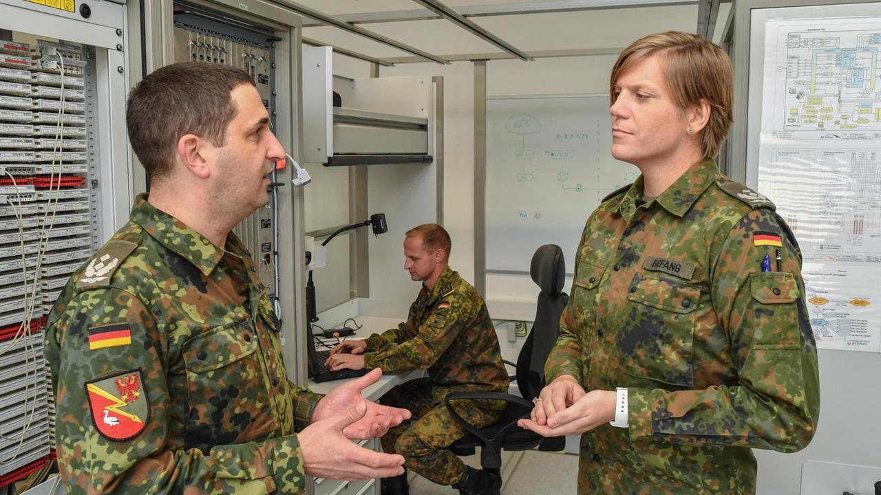 Oberstleutnant Anastasia Biefang (r) und ihr Vorgänger Oberstleutnant Thorsten Niemann, Standortältester der Kurmark Kaserne und Kommandeur des Führungsunterstützungsbataillons in Storkow (Brandenburg), unterhalten sich in einem Lehrraum einer Ausbildungsanlage für die Satellitenkommunikation. 