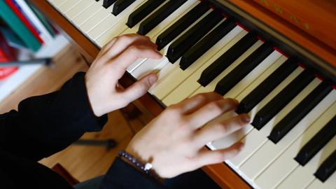 Ein Mädchen spielt an einem digitalen Klavier.