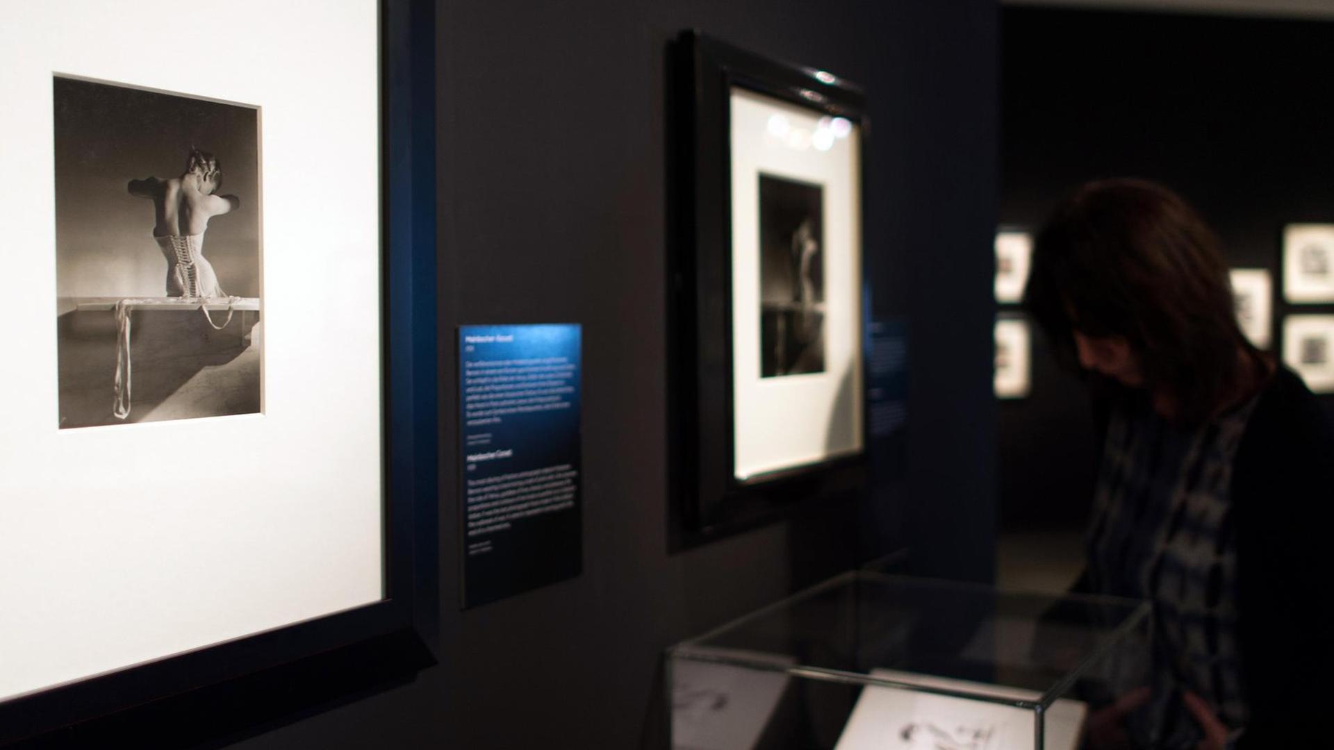 Eine Besucherin schaut sich in Düsseldorf (Nordrhein-Westfalen) die Fotografien des Fotografen Horst P. Horst an. Links im Bild ist das Foto "Mainbocher-Korsett" aus dem Jahr 1939 zu sehen.