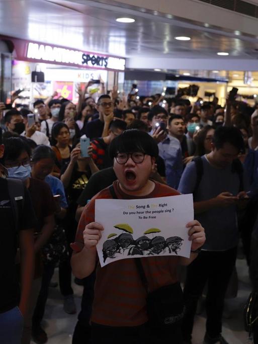Demonstranten in einem Hong Konger Shopping Center singen das Lied "Glory to Hong Kong"
