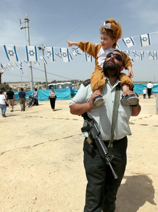 Ein Offizier der israelischen Armee trägt seinen Sohn auf den Schultern während einer Veranstaltung des Militärs am 62. Unabhängigkeitstages in der jüdischen Siedlung Efrat in der Westbank am 20. April 2010.