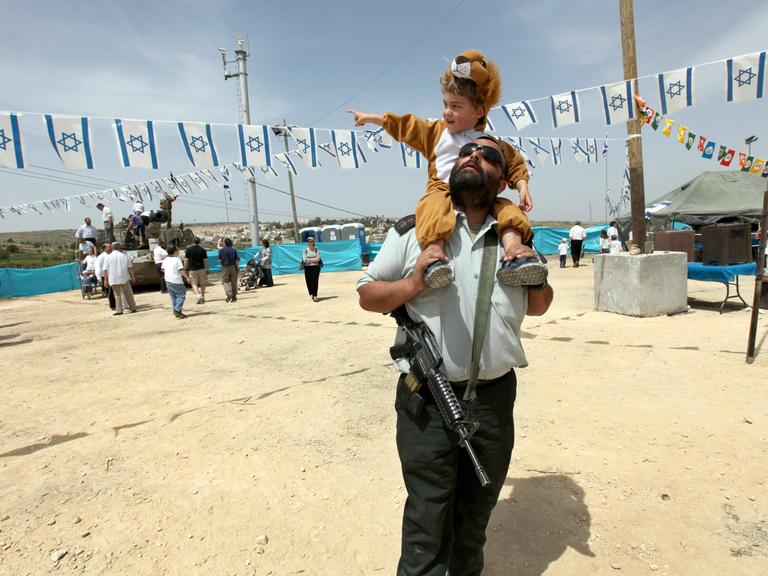 Ein Offizier der israelischen Armee trägt seinen Sohn auf den Schultern während einer Veranstaltung des Militärs am 62. Unabhängigkeitstages in der jüdischen Siedlung Efrat in der Westbank am 20. April 2010.