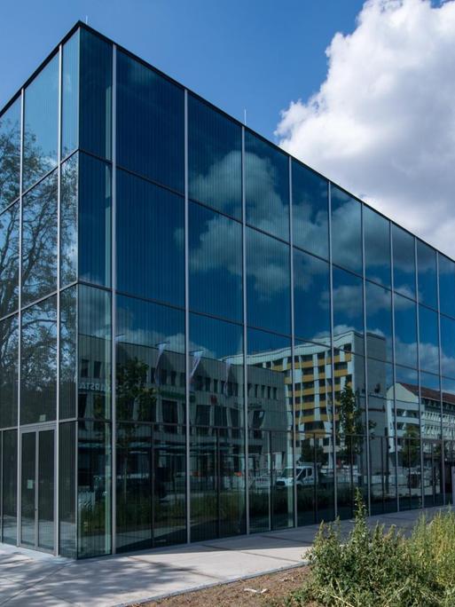 Das neue Bauhaus Museum. Ein spitzes Gebäude aus Glas, in dem sich die umliegenden Häuser spiegeln.