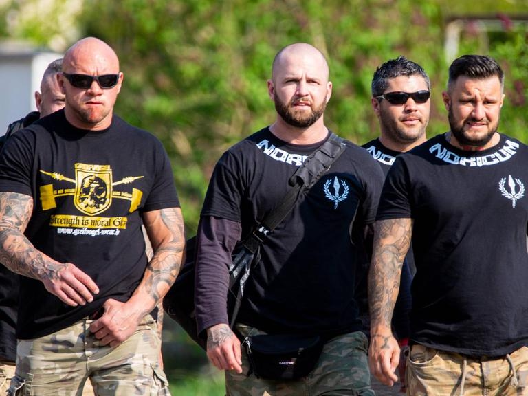 Vier Männer mit durchtrainierten Körpern auf ihren T-Shirts steht "Noricum", der Name ihrer Kampfsportgruppe