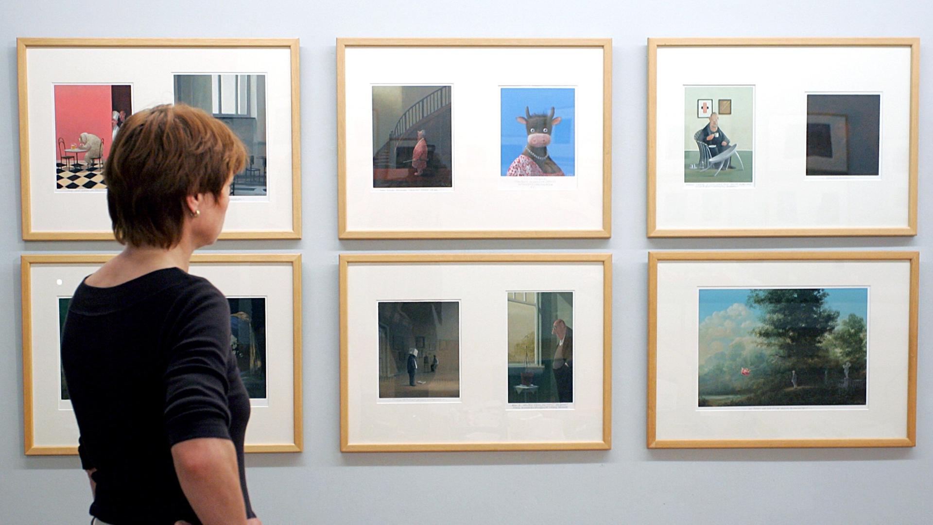Eine Mitarbeiterin des Museums betrachtet Bilder der Ausstellung "Gerhard Glück: Komische Kunst" im Wilhelm Busch Museum in Hannover, die vom 17. Juni bis zum 2. September 2007 zu sehen war.