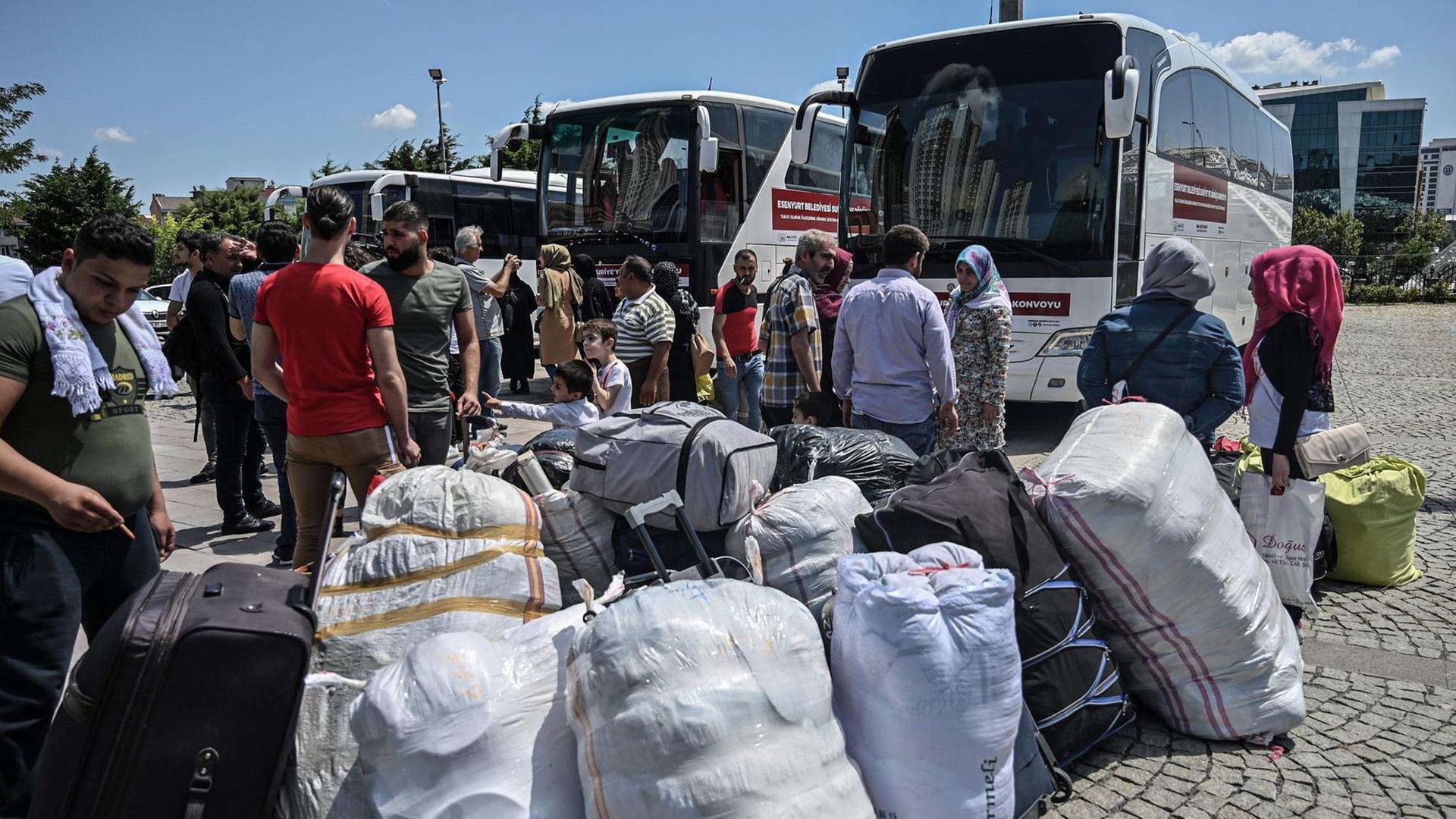 Syrische Flüchtlingsfamilien warten mit ihrem Gepäck neben mehreren Reisebussen, die sie vom türkischen Ort Esenyurt zurück nach Syrien bringen sollen, am 6. August 2019.