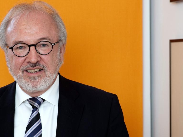 Der Vorsitzende des Marburger Bundes Rudolf Henke trägt schwarzen Anzug und gestreifte Krawatte.