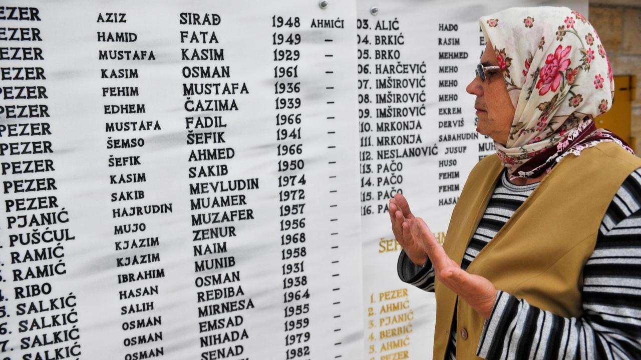 VITEZ, BOSNIA AND HERZEGOVINA - APRIL 16:  A woman prays at cemetery next to victims' names during the 23th anniversary of Ahmici massacre in Vitez, Bosnia and Herzegovina on April 16, 2014. In Ahmici, Croatian forces killed 116 Bosnian civilians in April 1993, during the short period in the war when Bosnians and Croatians fought each other in Vitez, central Bosnia and Herzegovina.  Samir Yordamovic / Anadolu Agency | Keine Weitergabe an Wiederverkäufer.