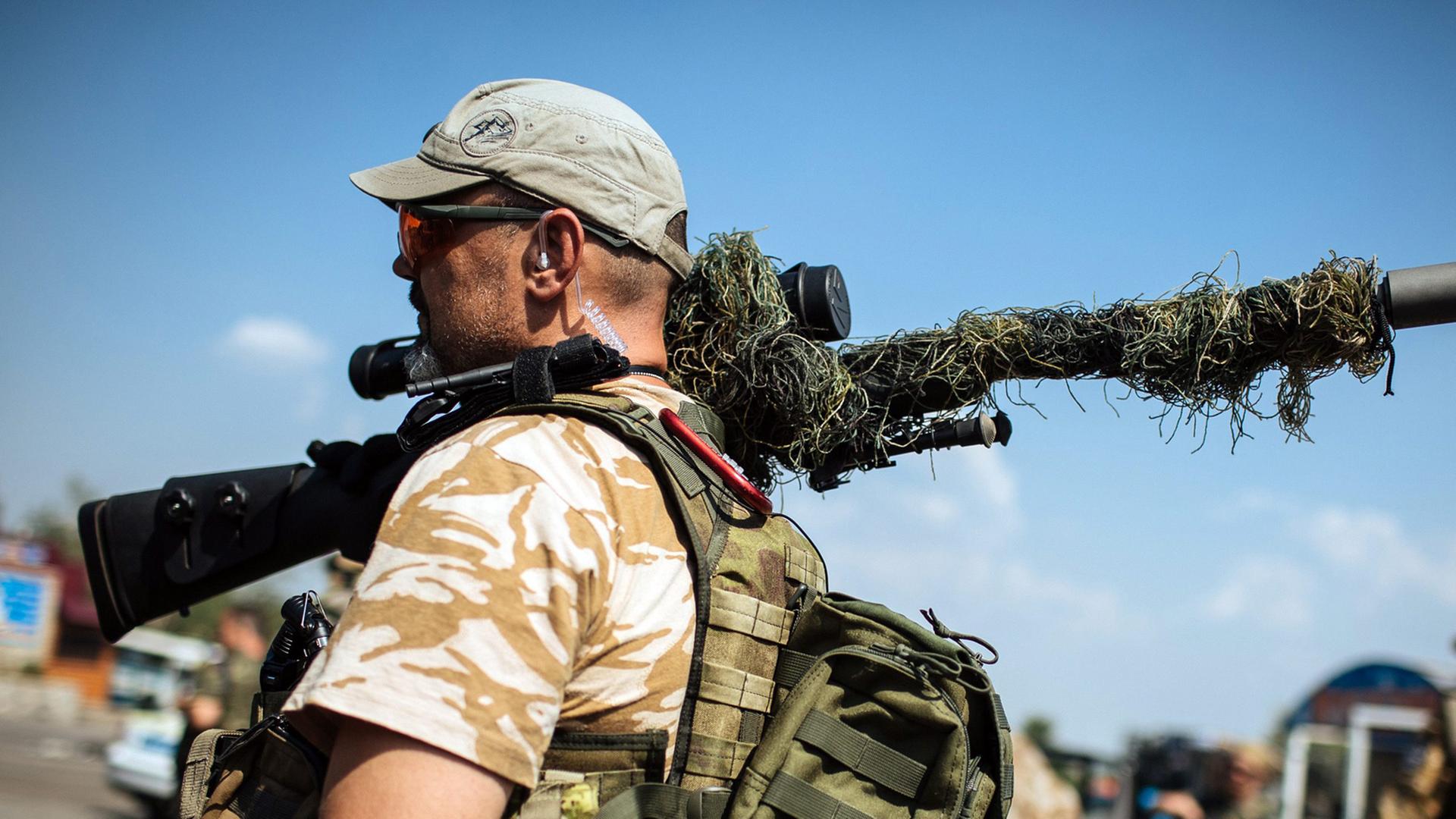 Ein ukrainischer Soldat hat an einem Checkpoint nahe Debalzewo ein Gewehr geschultert.