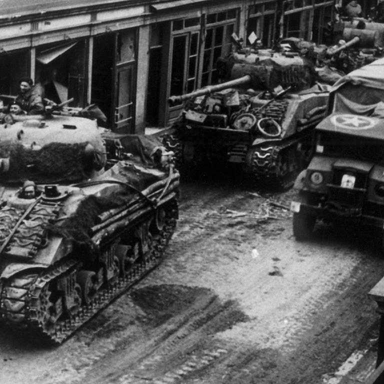 Panzer der Alliierten fahren beim Vormarsch im März 1945 durch die Straßen der Stadt Kevelear.