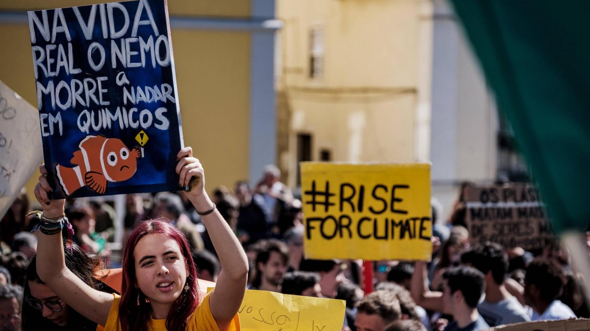 "Fridays for Future"-Demonstration in Lissabon: Eine Demonstrantin hält ein Plakat mit einem Clownfisch hoch, auf dem steht: "Im wahren Leben stirbt Nemo, weil er in Chemikalien schwimmt"