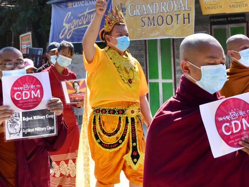 Mönche nehmen an einem Protestmarsch teil und halten Schilder mit der Aufschrift "CDM - Reject military coup" (Bewegung für zivilen Ungehorsam (CDM) - Militärputsch ablehnen).