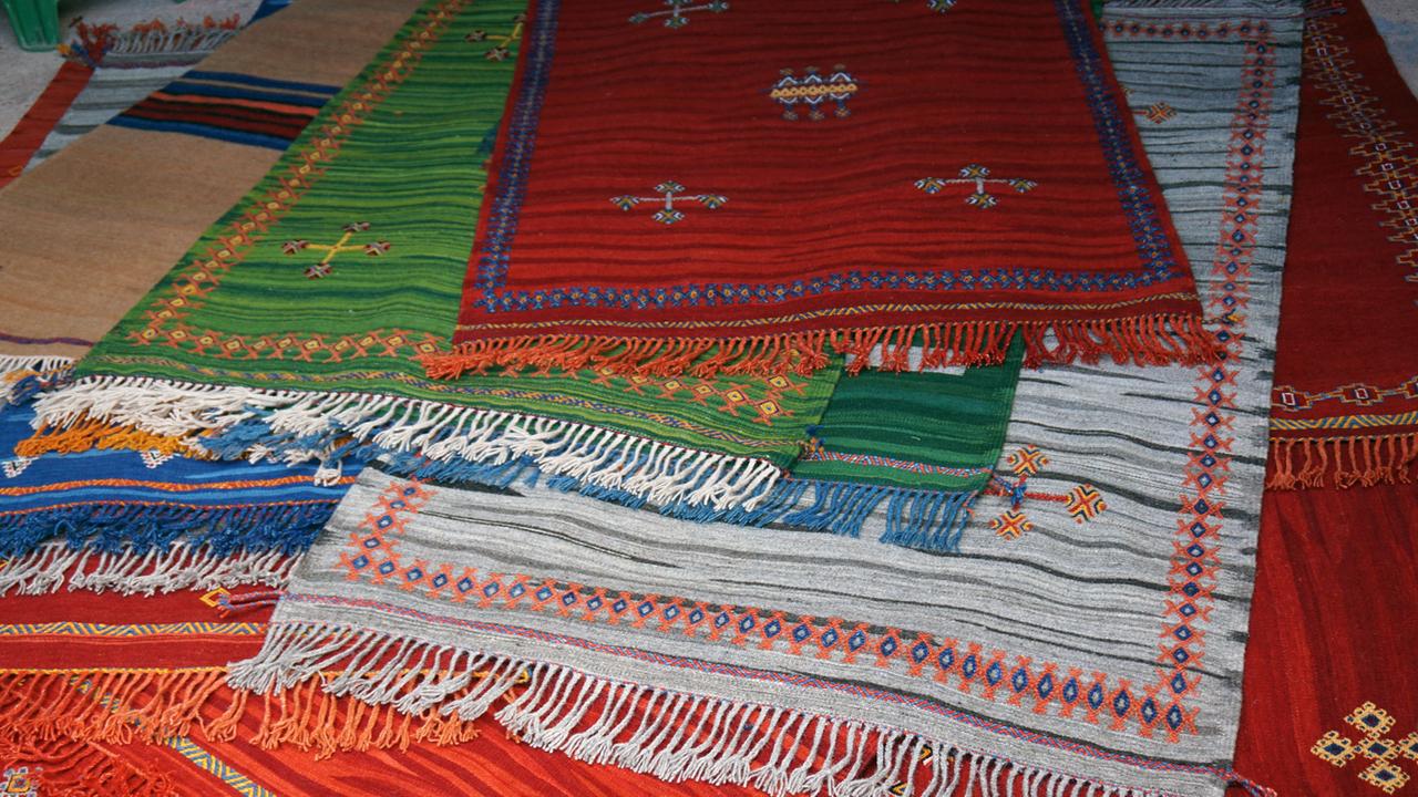 Zu sehen sind mehrere aufeinander liegende Teppiche aus Marokko.