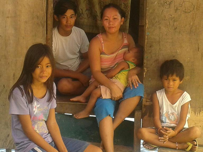 Die 28 Jahre alte Shereline (Bildmitte) sitzt auf der Türschwelle eines Hauses, umringt von ihren Kindern und Geschwistern.
