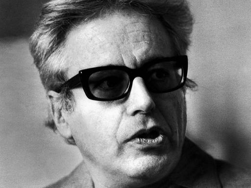 Schwarz-Weisses Porträt eines Mannes mit Sonnenbrille, der zur Seite sieht.