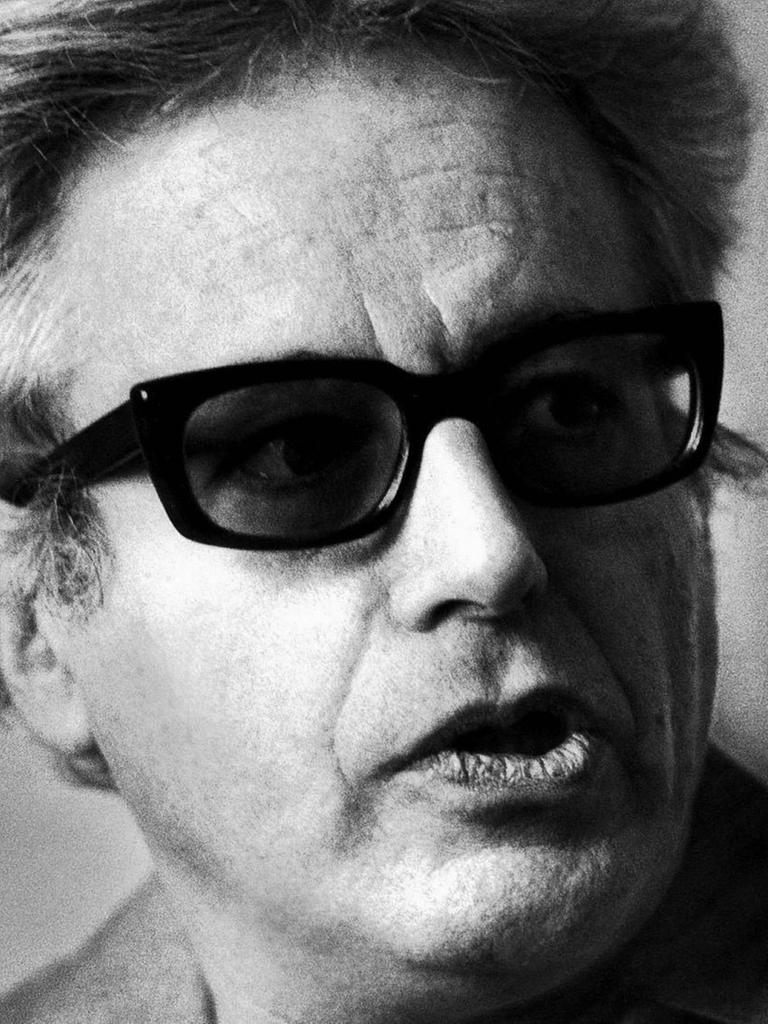 Schwarz-Weisses Porträt eines Mannes mit Sonnenbrille, der zur Seite sieht.
