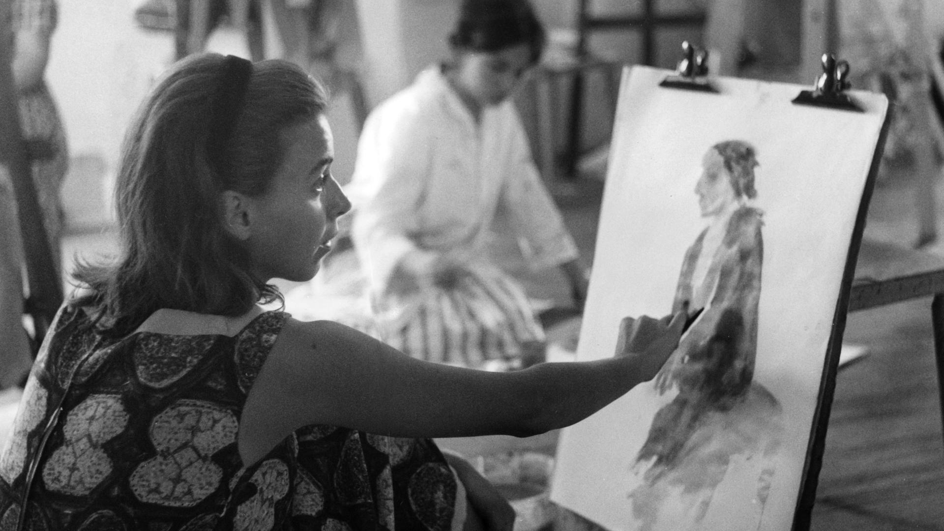 Contessa Maria Camilla Pallavicini malt an einem Bild von einer Frau. Im Hintergrund sieht man eine weitere Künstlerin.