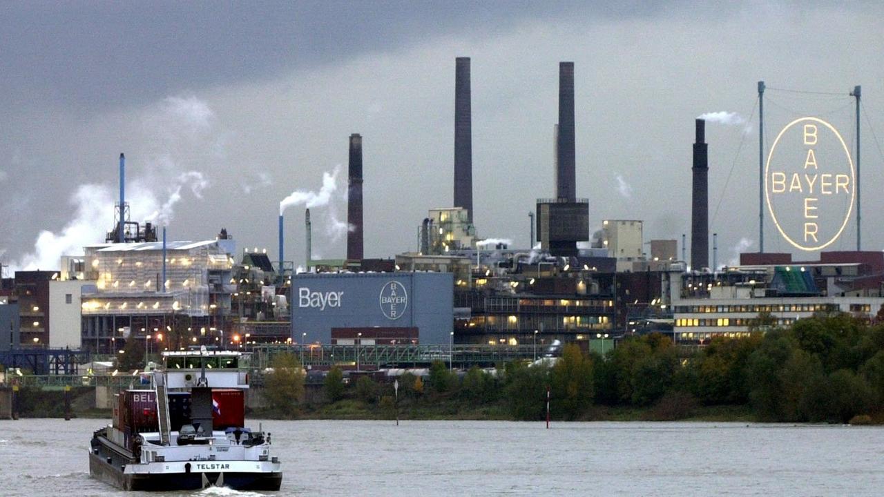 Die Fabrik liegt am Rhein, davor fahren Schiffe vorbei.
