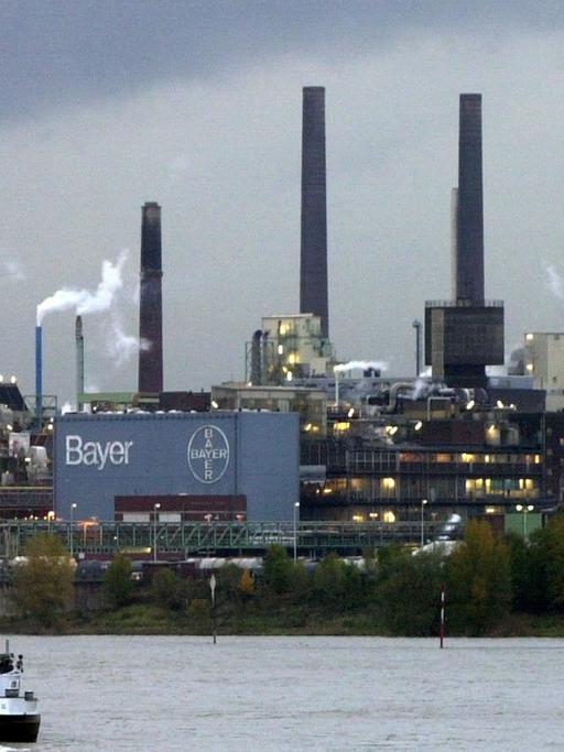 Schiffe fahren auf dem Rhein am Chemie- und Pharmakonzern Bayer in Leverkusen vorbei.