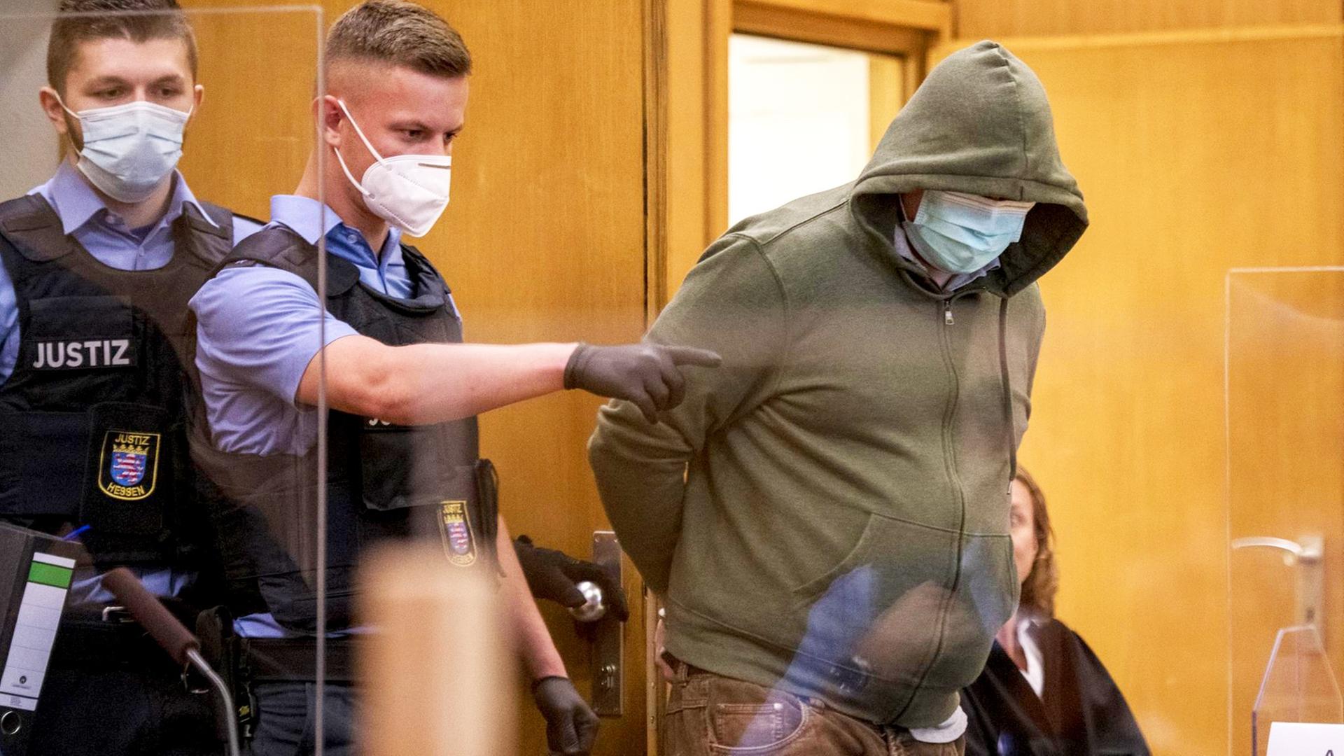 Frankfurt/Main: Markus H. (r), der wegen Beihilfe zum Mord an Politiker Lübcke angeklagt ist, trägt einen Mundschutz, als er am ersten Tag des Prozesses von Polizisten in einen Gerichtssaal des Oberlandesgericht gebracht wird.