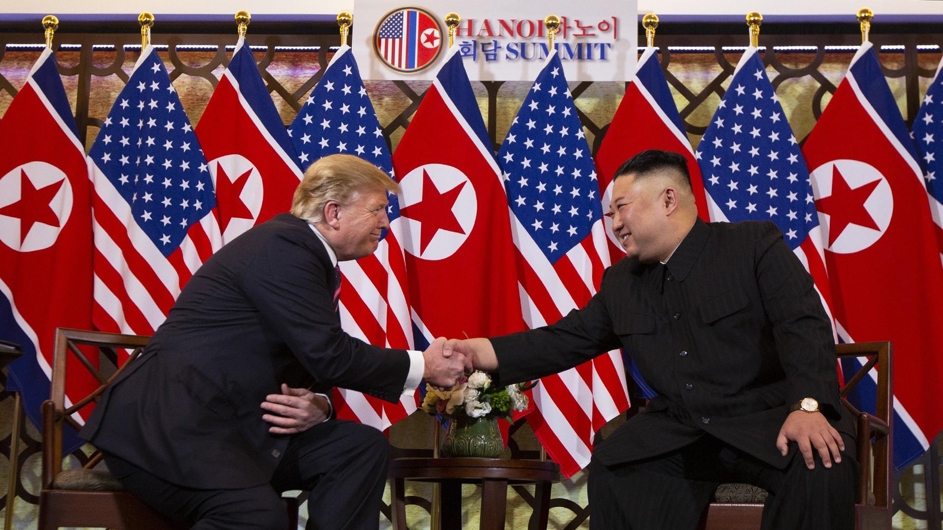 US-Präsident Donald Trump und der nordkoreanische Diktator Kim Jong Un reichen sich die Hände und lächeln sich an.