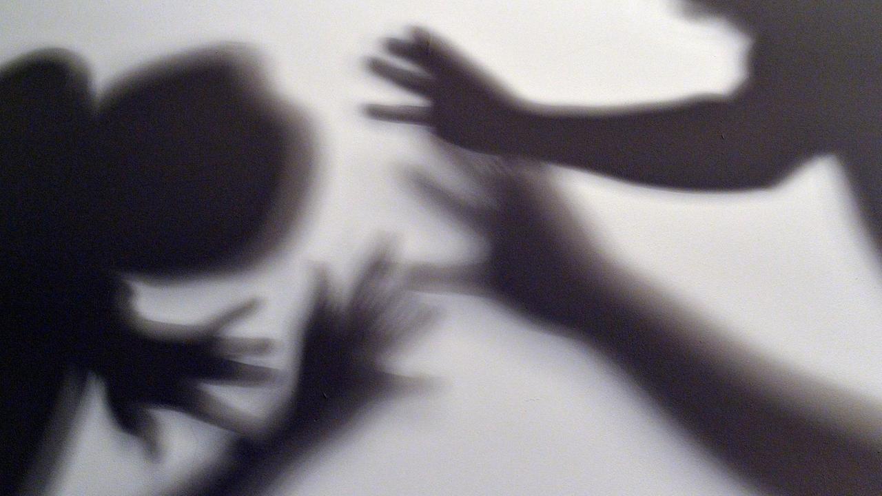 Das gestellte Bild zum Thema häusliche Gewalt symbolisiert, wie ein Kind versucht, sich vor der Gewalt eines Erwachsenen zu schützen.