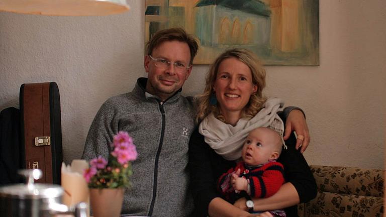 Katharina - mit ihrem jüngsten Kind auf dem Schoß - und Frank Freudenberg, Kirchenhistorikerin und Pfarrer in Schlotheim in einem Wohnzimmer